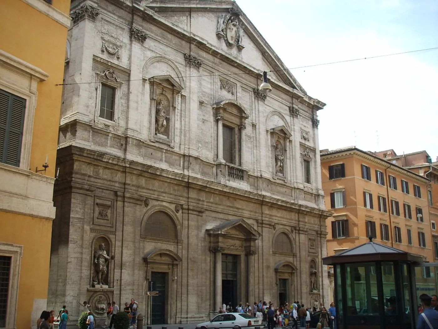The travertine front of San Luigi dei Francesi, two storeys with niches, statues and a pediment, on a small square