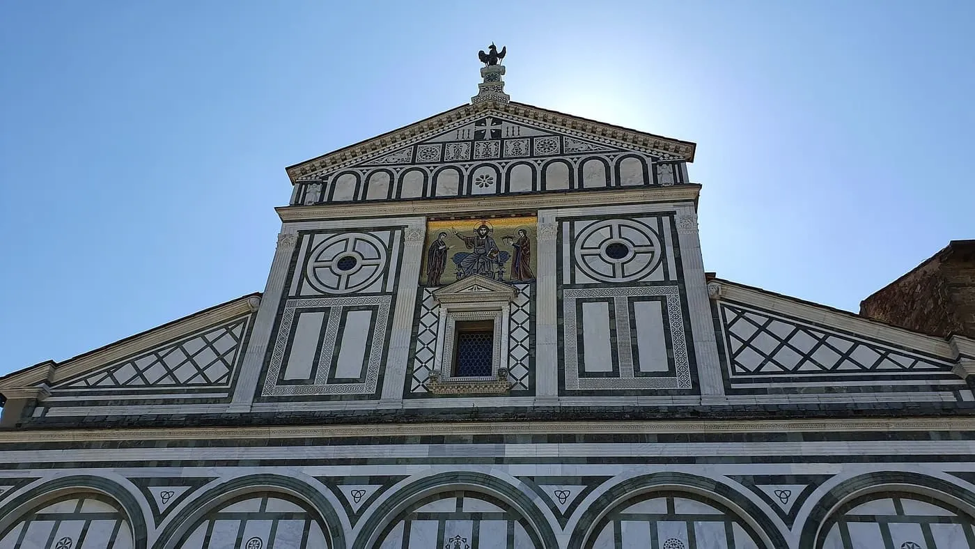 The upper part of the San Miniato al Monte front, with geometric marble panels and a gold mosaic of Christ