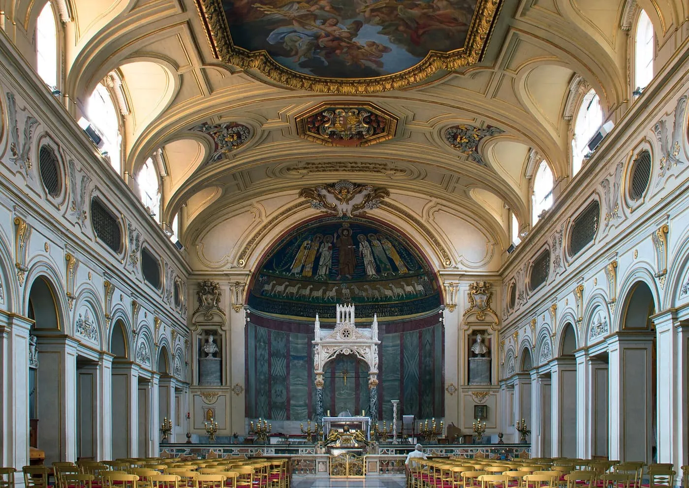 The nave of Santa Cecilia in Trastevere, white and gold, with the apse mosaic and a white Gothic canopy over the altar