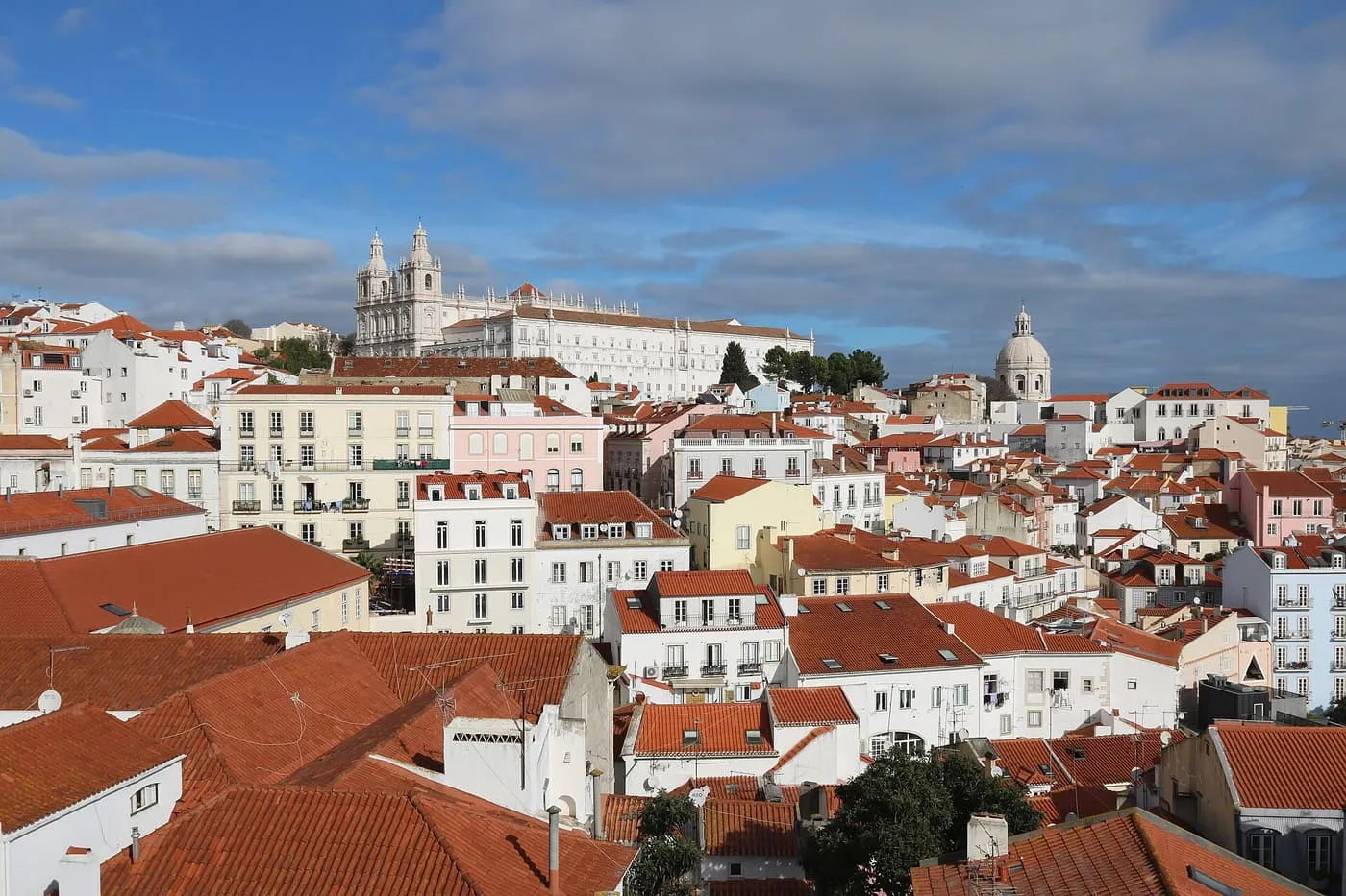 Alfama's red-tiled roofs below the towers of São Vicente de Fora and the dome of the National Pantheon