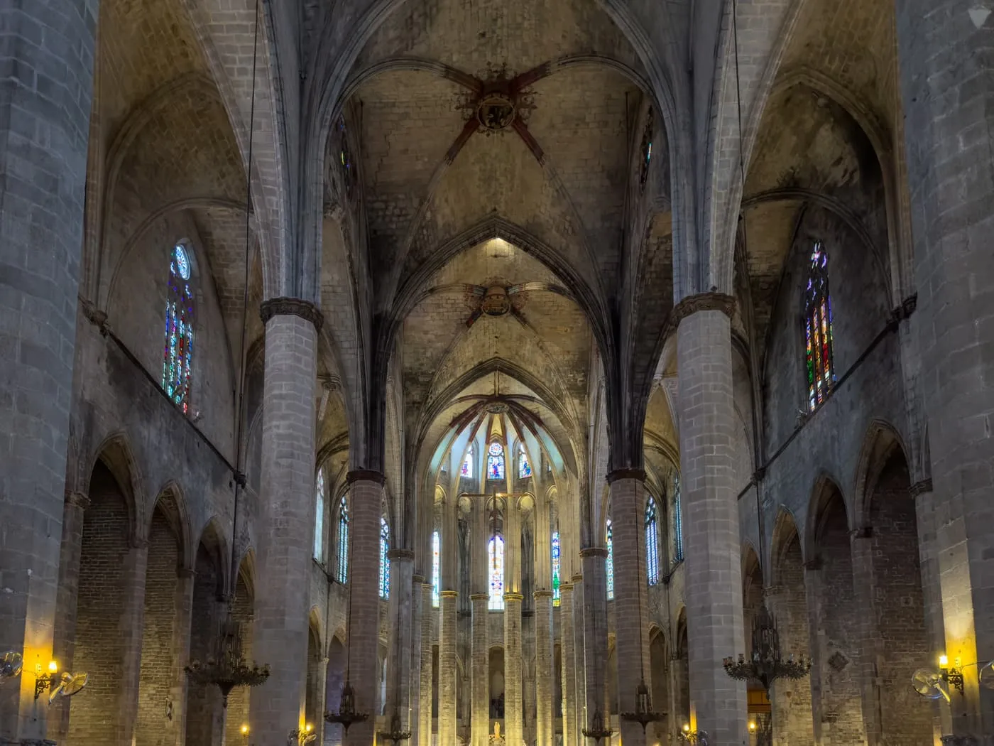 The nave of Santa Maria del Mar, tall octagonal pillars carrying the vaults towards the lit apse