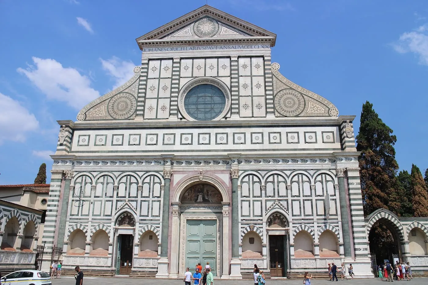 The green and white marble front of Santa Maria Novella with its round window and triangular pediment
