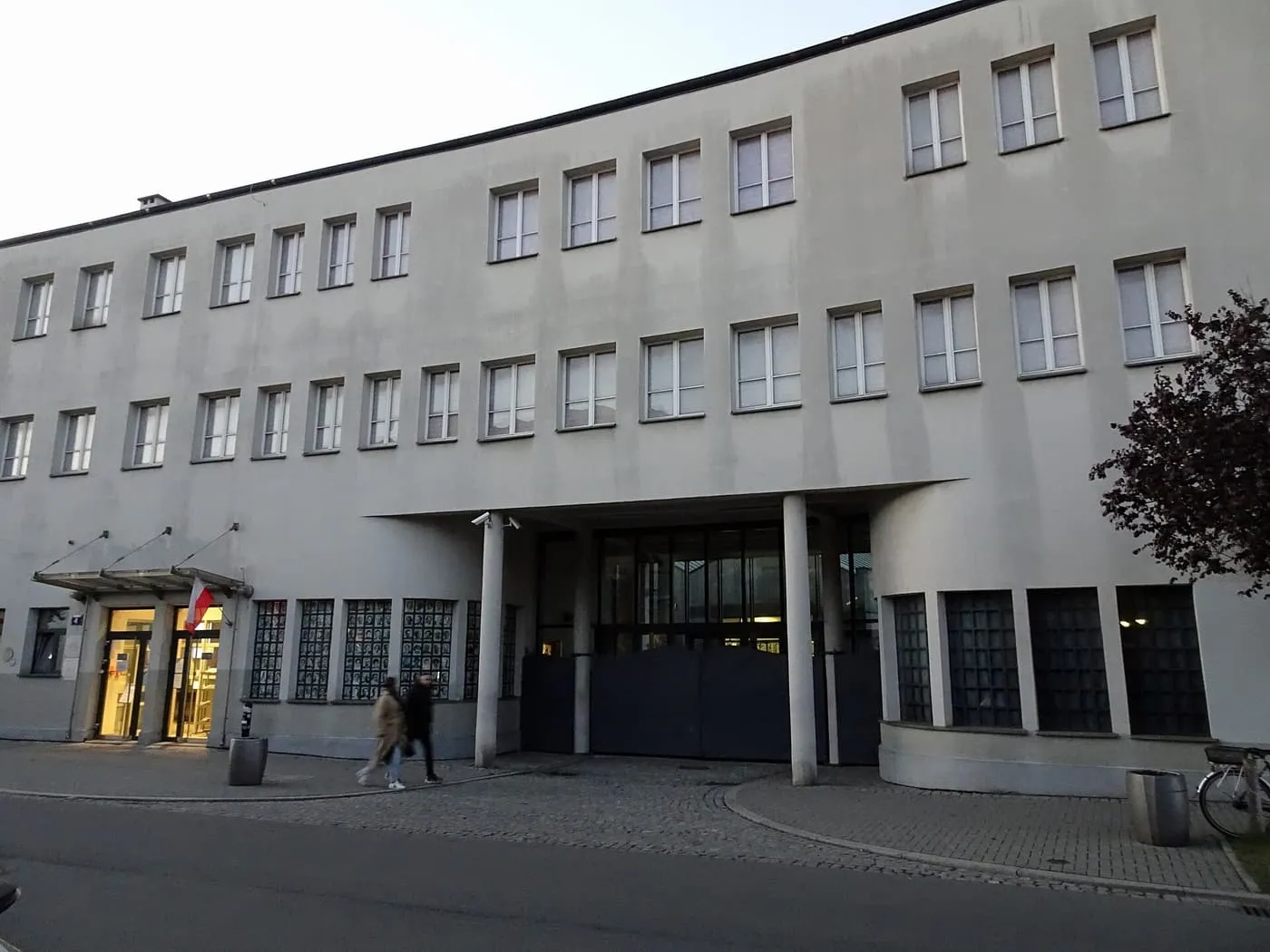 The flat-fronted factory building on ul. Lipowa, with its entrance under a concrete canopy and columns