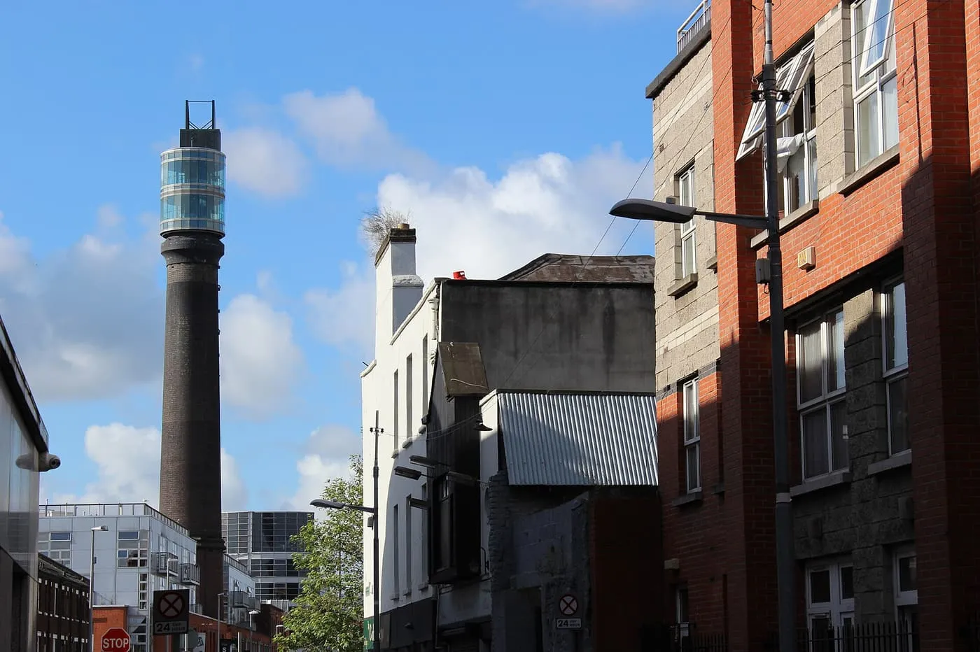 The tall brick chimney at Smithfield with a glass observation platform at its top, seen between houses