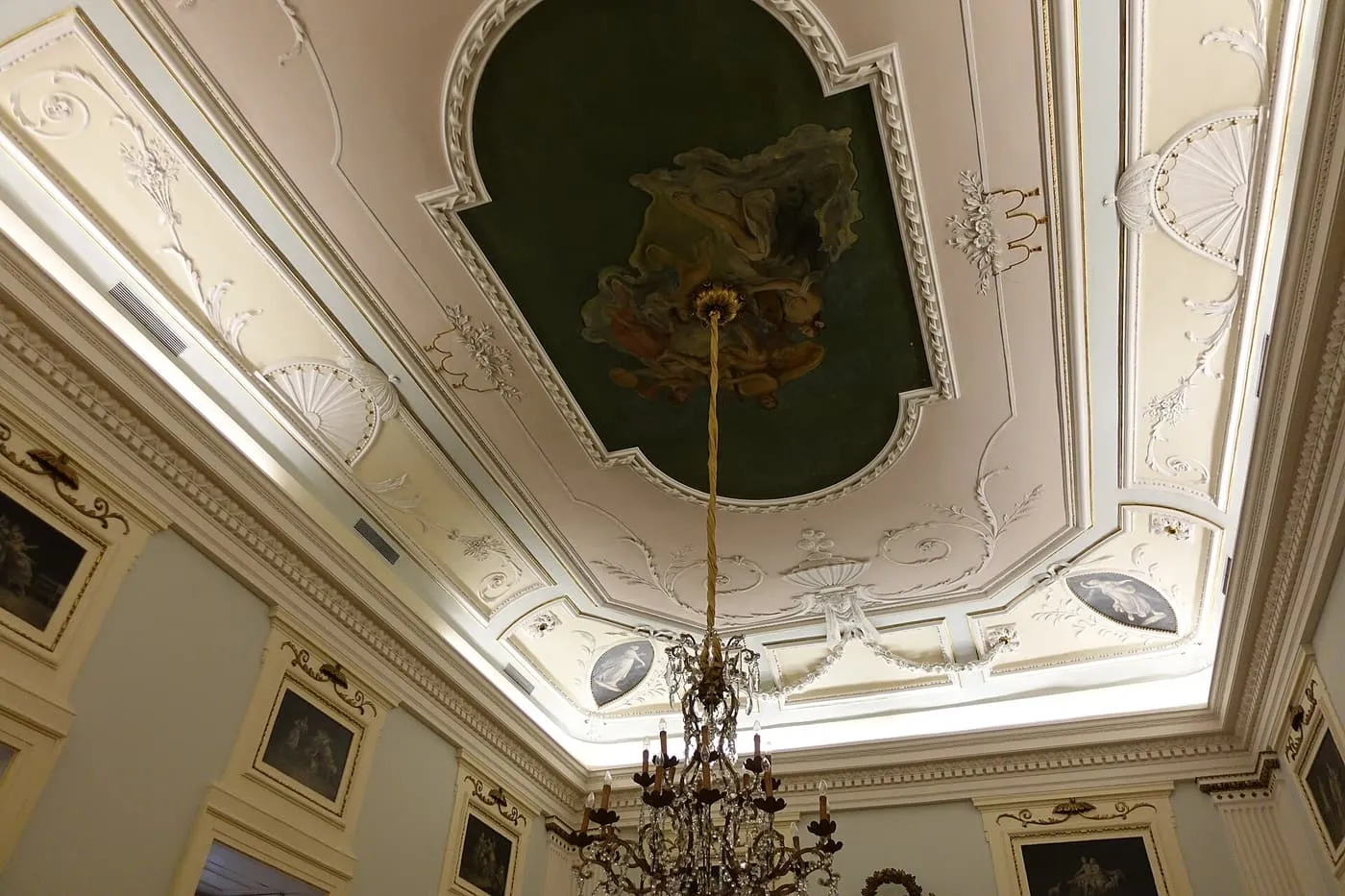 A first-floor room of the Museu Nacional Soares dos Reis, with a painted ceiling, white stucco mouldings and a chandelier