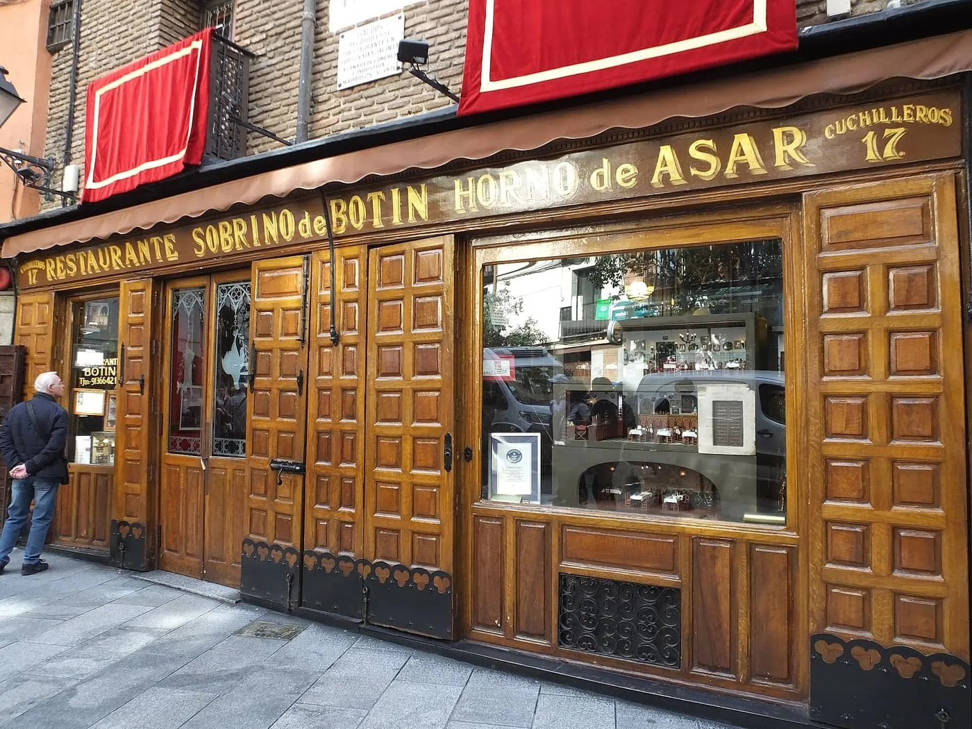 The carved wooden front of Sobrino de Botín on Calle de Cuchilleros, with the gilded lettering reading Restaurante Sobrino de Botín, Horno de Asar, Cuchilleros 17