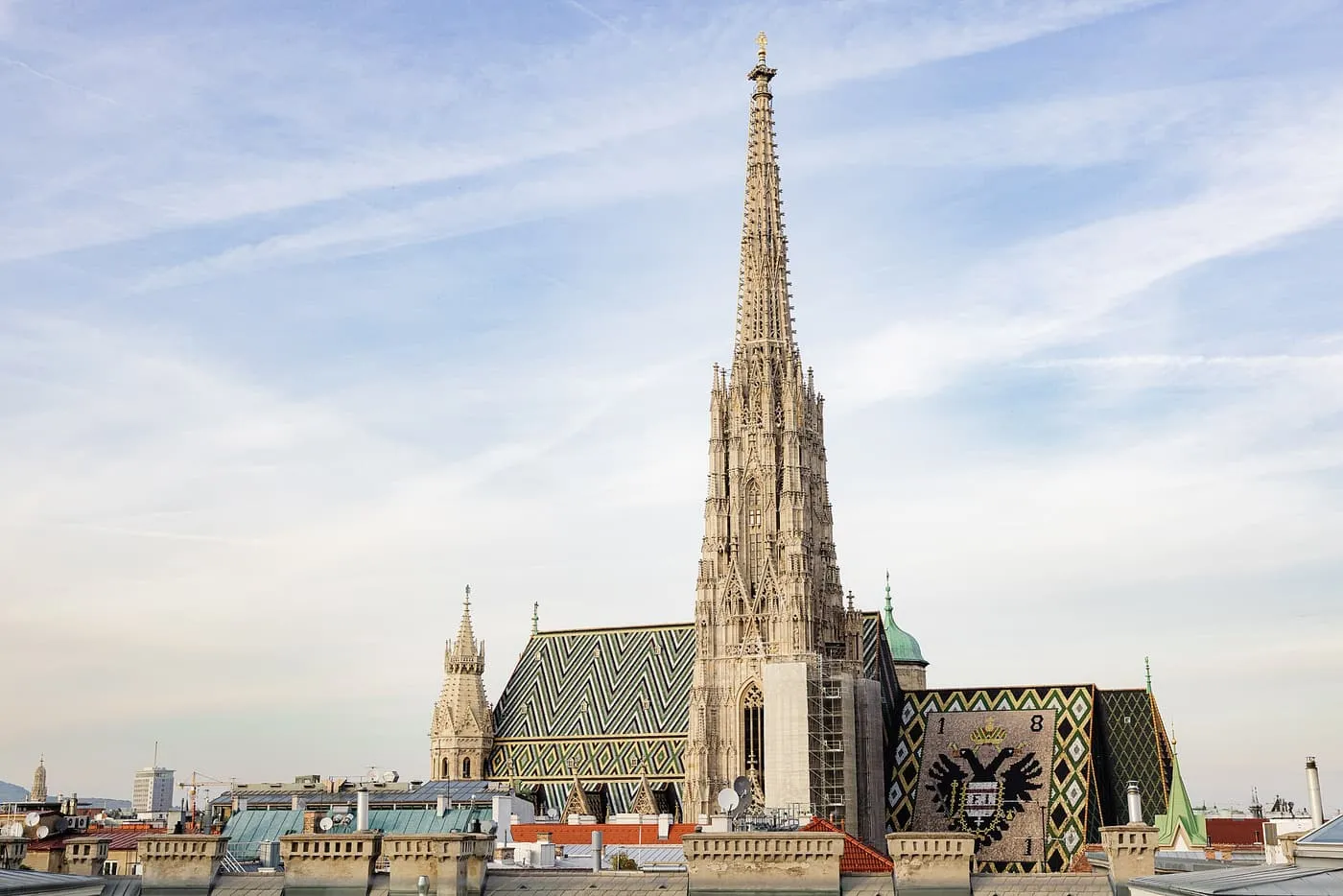 St Stephen's Cathedral's South Tower rising above the tiled roofs, with the zigzag-patterned roof and a double eagle in coloured tiles on the side roof