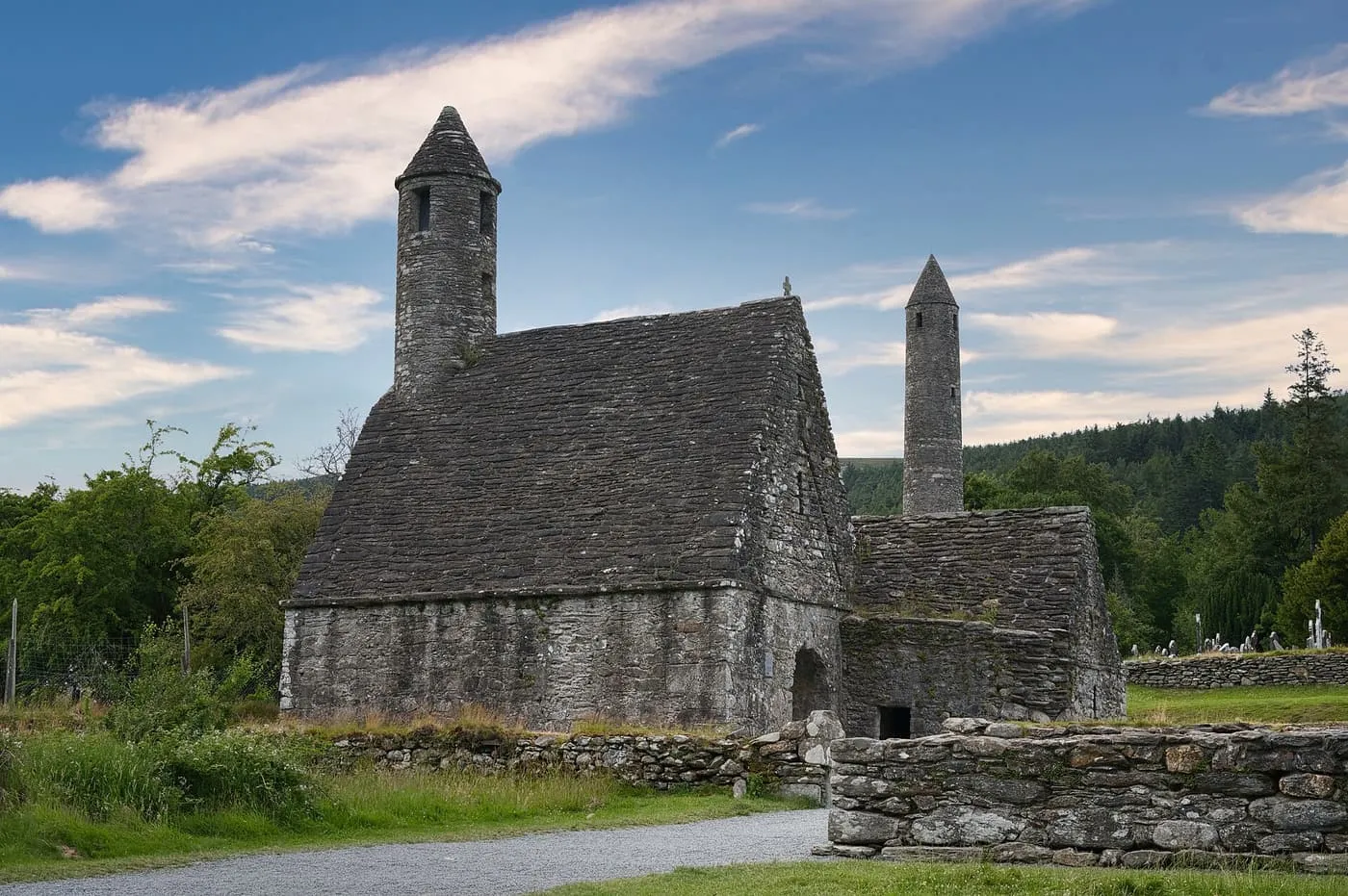 St Kevin's Church at Glendalough, a stone-roofed building with a small round bell tower, and the tall round tower rising behind it