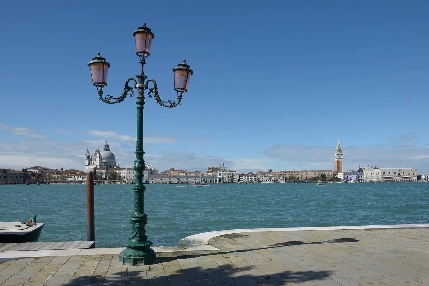A green lamp post on the Giudecca quay with the Salute, the Campanile and the Doge's Palace across the water