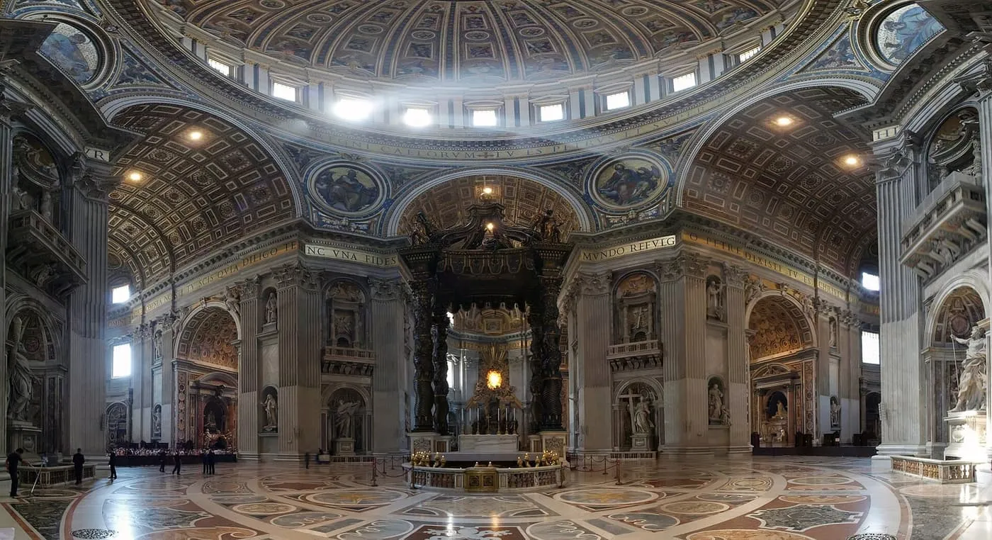 The dome and Bernini's bronze baldachin over the high altar in St Peter's Basilica, with a marble floor in the foreground