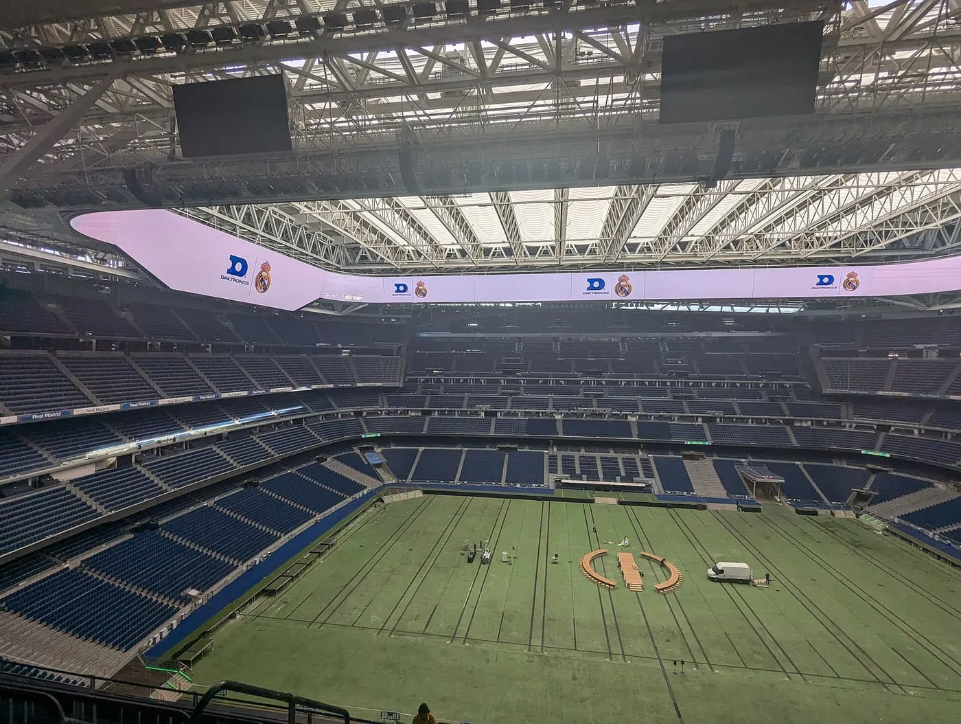 The empty blue seats of the Santiago Bernabéu rising in tiers above the pitch, under the roof and a ring of video screens