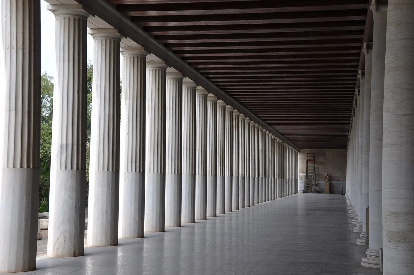 The marble Doric colonnade of the Stoa of Attalos, a row of fluted columns under a wooden ceiling