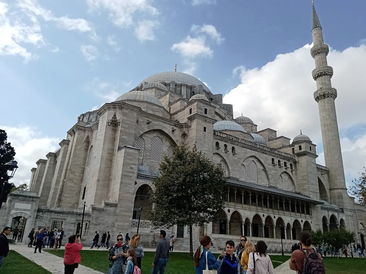 The Süleymaniye Mosque with its great dome and a tall minaret, and visitors in the foreground