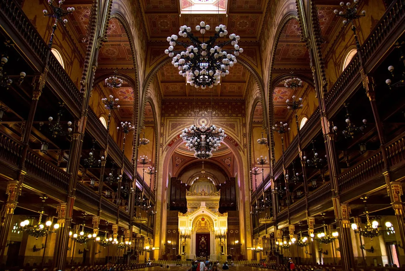 The nave of the Dohány Street Synagogue, with two tiers of galleries, chandeliers and the ark at the far end