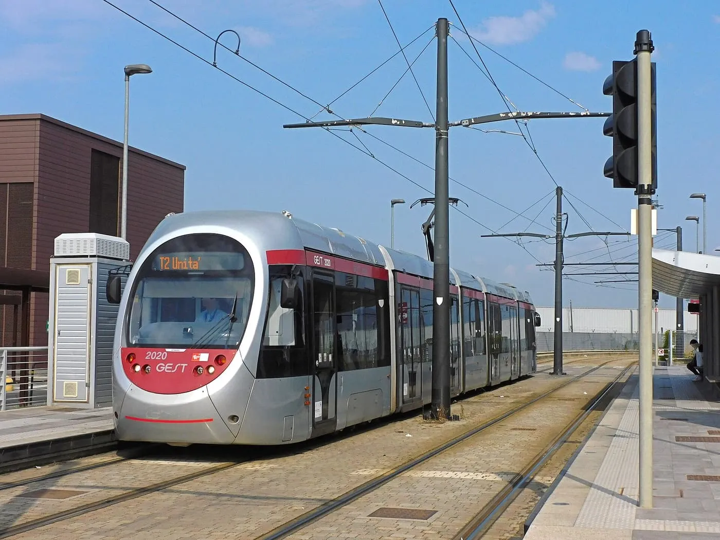 A silver and red T2 tram standing at the Peretola Airport stop in Florence