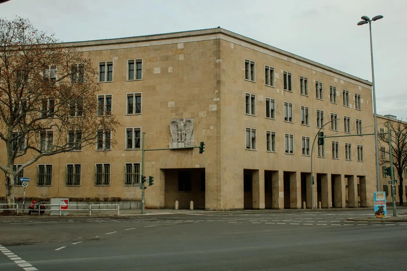 A corner of the former Tempelhof airport building, a stone-faced block with an eagle relief above an arcade