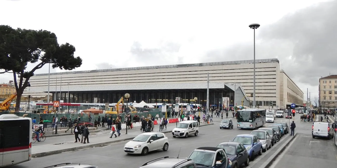 The long travertine front of Roma Termini with its wide canopy, seen across Piazza dei Cinquecento