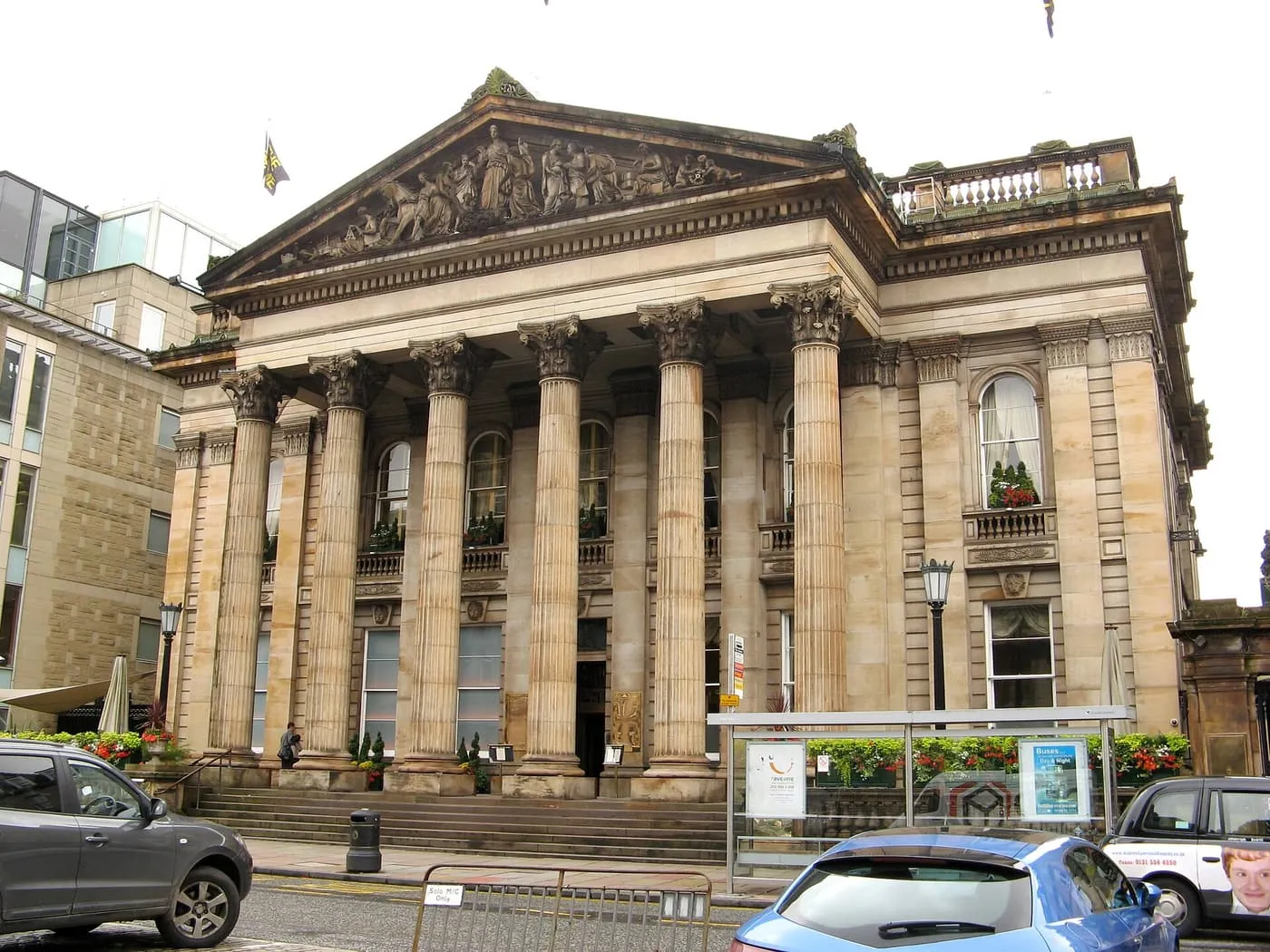 The Dome on George Street: a portico of six tall columns under a carved pediment, with a bus shelter and parked cars at the kerb