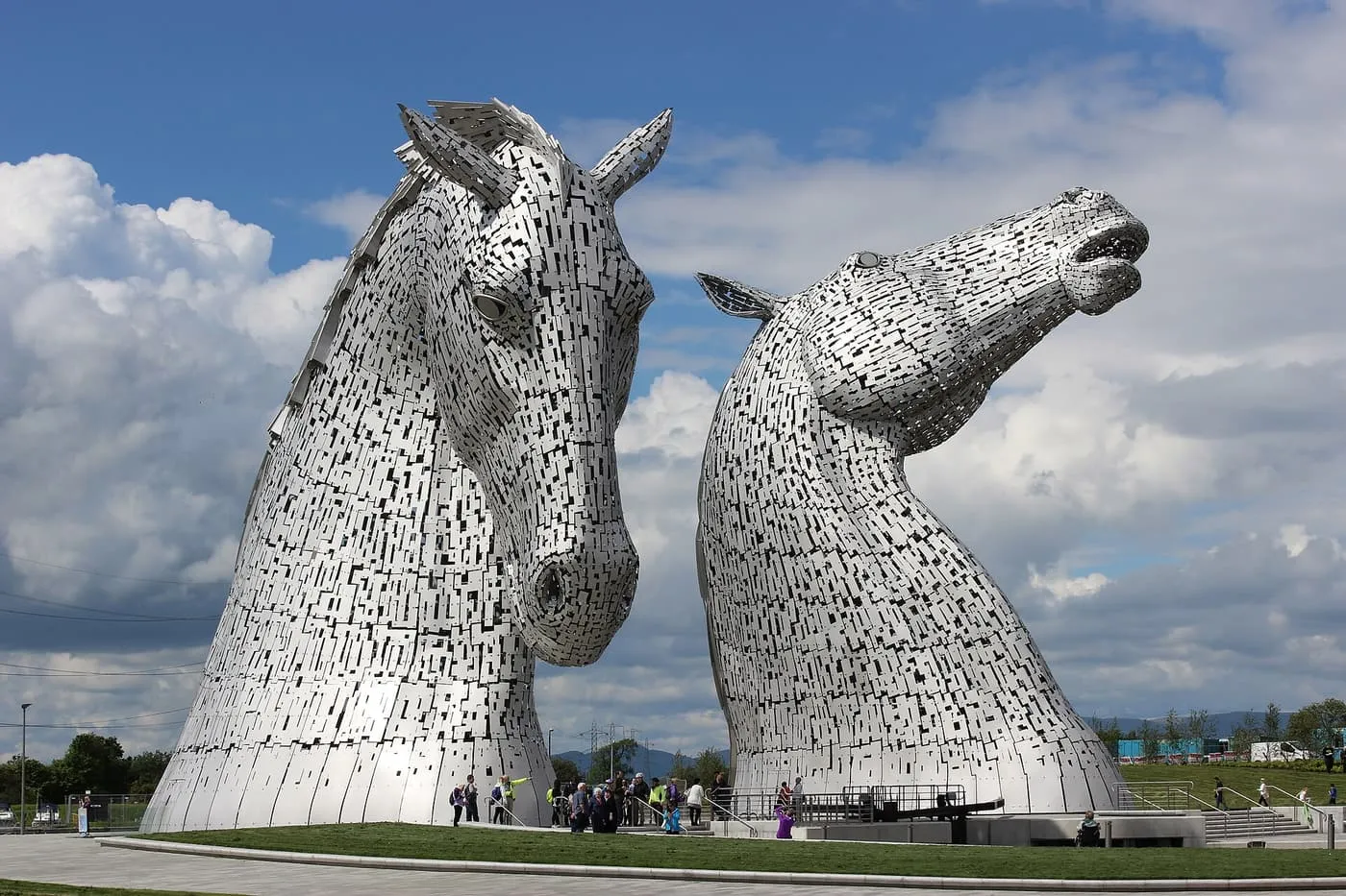 The two Kelpies, steel horse-head sculptures, rising above the park at The Helix with visitors at their base