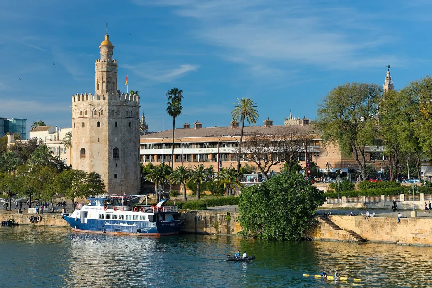 The Torre del Oro beside the Guadalquivir, with a tour boat moored in front of it