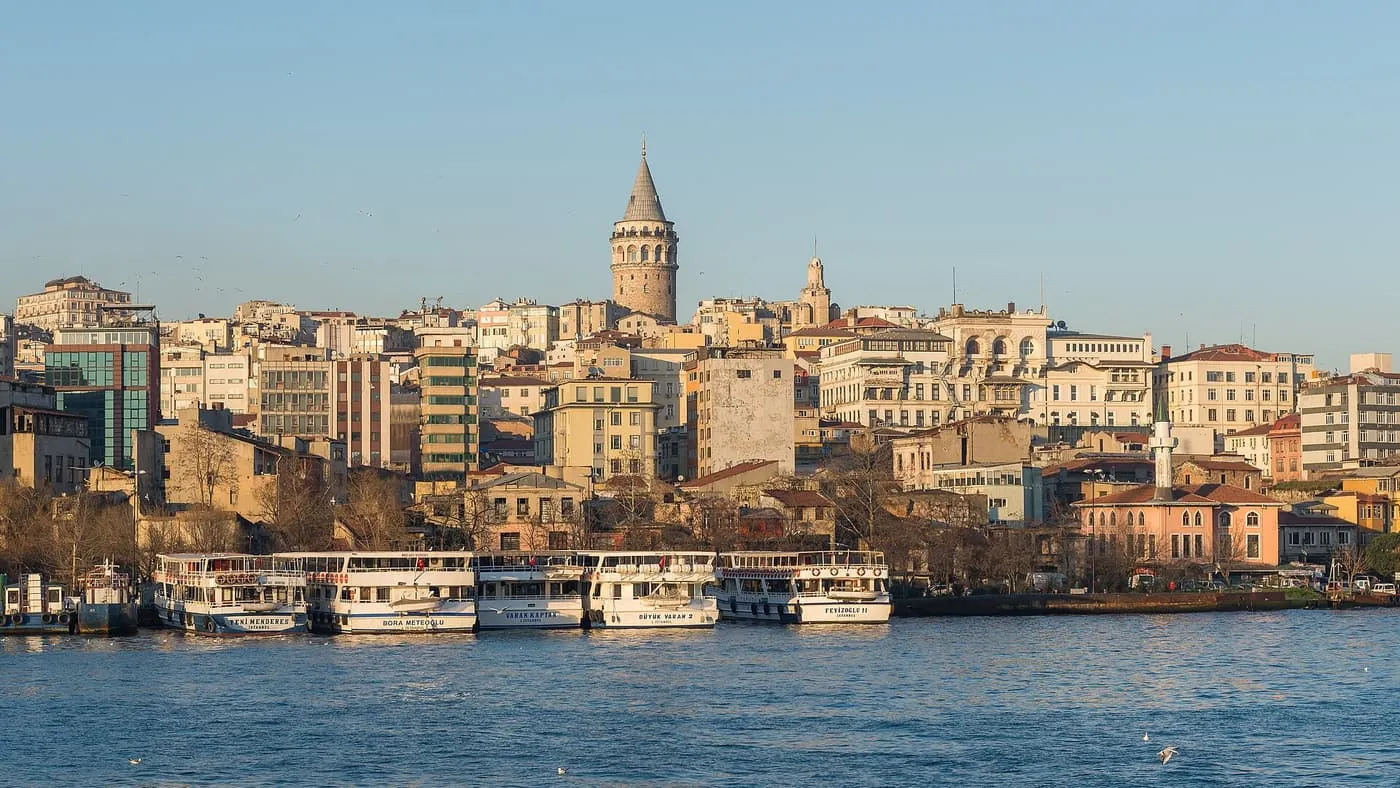 The Galata Tower on its hill above the houses of Karaköy, with ferries moored at the waterfront below