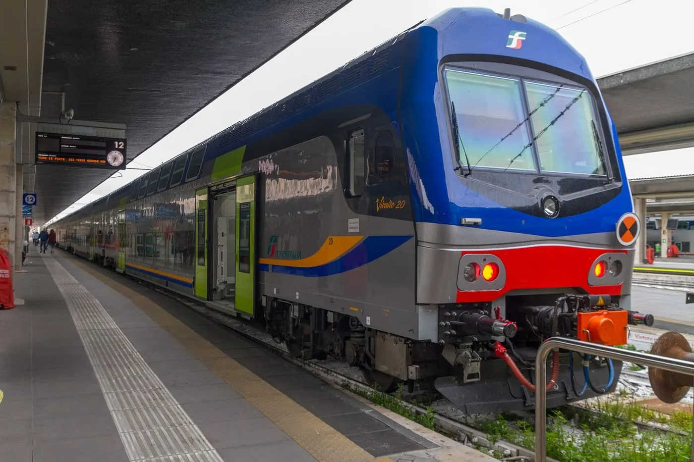A blue and grey Trenitalia double-deck regional train standing at platform 12 of Venezia Santa Lucia