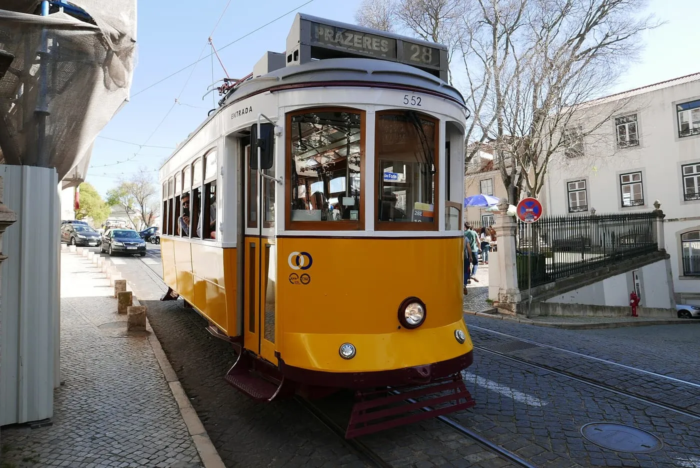 A yellow tram 28 with its destination board showing Prazeres, on a cobbled street
