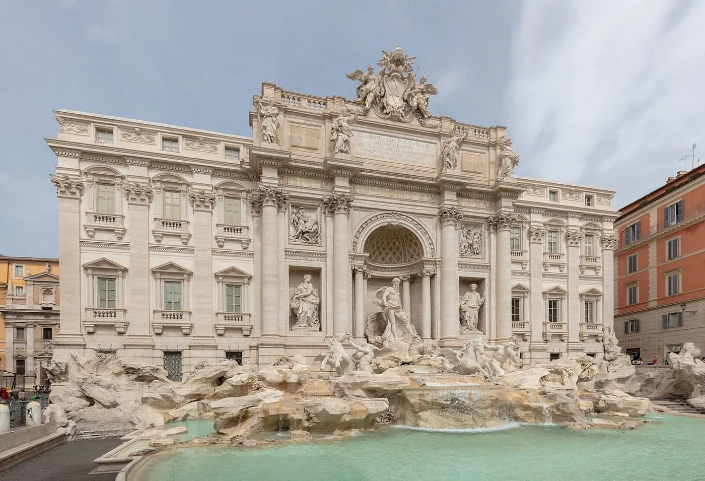 The Trevi Fountain from the square in daylight, with Neptune's niche above the rocks and the turquoise basin in front