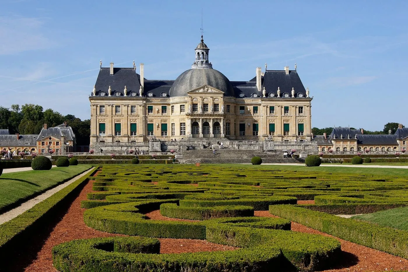 The domed château of Vaux-le-Vicomte with its slate roofs and stone steps, seen across clipped box parterres