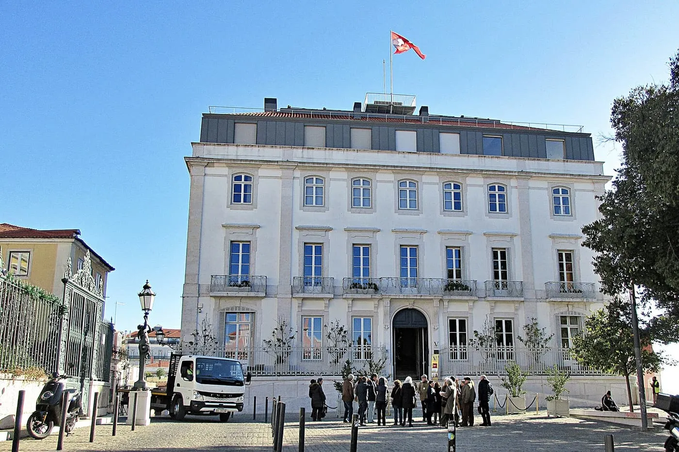 The pale three-storey front of the Verride Palácio Santa Catarina, with its arched doorway and a flag on the roof