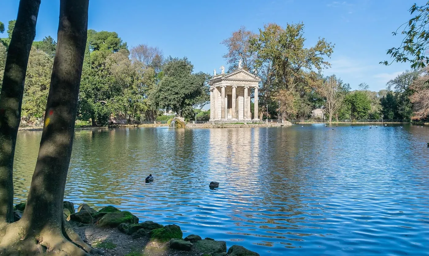 The Temple of Aesculapius on an island in the lake in Villa Borghese park, reflected in the water