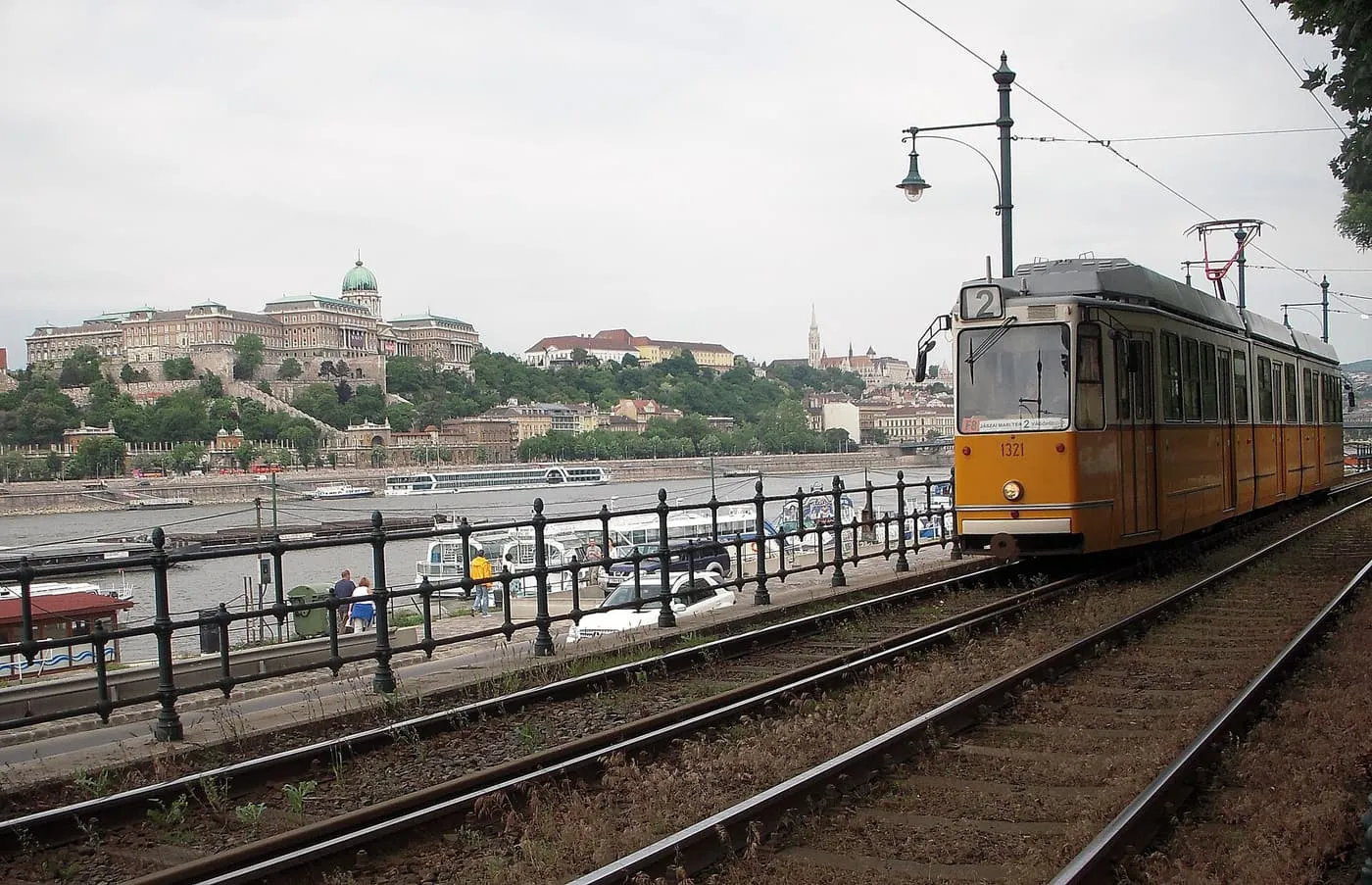 A yellow tram 2 on the Pest embankment, with the Danube and Buda Castle on the far bank