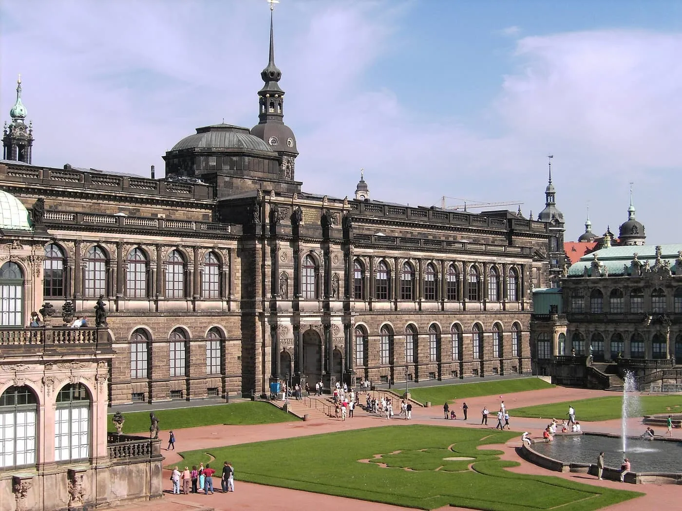 The Zwinger courtyard in Dresden, with lawns and a fountain in front of the dark stone Semper building, which houses the Old Masters Picture Gallery